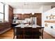 Modern kitchen features island with seating, wood cabinets, stainless steel appliances, and exposed brick at 2261 Blake St # 2G, Denver, CO 80205