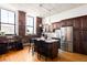 Spacious kitchen with stainless steel appliances, wood cabinets, exposed brick, and adjacent dining area at 2261 Blake St # 2G, Denver, CO 80205
