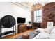 Comfortable living area featuring exposed brick, hardwood floors and an elegant modern light fixture and decor at 2261 Blake St # 2G, Denver, CO 80205