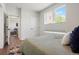 Serene bedroom with large window, neutral tones, and view to additional bedrooms at 2120 N Downing St # 209, Denver, CO 80205