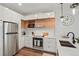 Bright and modern kitchen featuring stainless steel appliances, quartz countertops, and stylish pendant lighting at 2120 N Downing St # 209, Denver, CO 80205