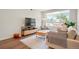 Bright living room with large windows, a cozy couch, a contemporary rug on hardwood floors, and stylish furniture at 2120 N Downing St # 209, Denver, CO 80205