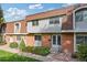 Brick front of a two-story townhome with landscaping at 12974 W Virginia Ave, Lakewood, CO 80228