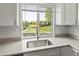 Kitchen sink featuring light quartz countertops and a bright window with a beautiful view of the neighborhood at 11182 W 103Rd Cir, Broomfield, CO 80021