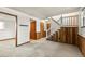 The open plan living area has wood paneling, neutral carpet and stairs leading to the home's upper level at 11182 W 103Rd Cir, Broomfield, CO 80021