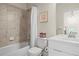 Bright bathroom featuring a shower and tub combo, white vanity and modern light fixtures at 2754 W 69Th Ave, Denver, CO 80221