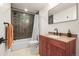 A bathroom features a modern vanity, rectangular mirror, and tub with dark tile surround at 2754 W 69Th Ave, Denver, CO 80221