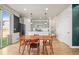 Bright dining area with wooden table and chairs flowing into an open-concept kitchen with sleek gray cabinets at 2754 W 69Th Ave, Denver, CO 80221