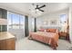 Light-filled main bedroom with a large window, wood furnishings, and a comfortable queen-sized bed and ceiling fan at 2754 W 69Th Ave, Denver, CO 80221