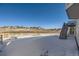 Backyard in winter showing a white fence, surrounding houses, and a staircase to the deck at 4689 Coltin Trl, Castle Rock, CO 80104