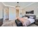 A light-filled bedroom with ensuite bathroom access features plush carpet and neutral paint at 4689 Coltin Trl, Castle Rock, CO 80104