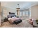 Spacious bedroom featuring a tray ceiling, large windows, and a cozy sitting area at 4689 Coltin Trl, Castle Rock, CO 80104