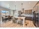 Modern kitchen with stainless steel appliances, island seating, and adjacent dining area at 4689 Coltin Trl, Castle Rock, CO 80104