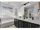 Well-lit bathroom featuring dual vanity, glass block window, and modern fixtures at 1894 S Marshall Cir, Lakewood, CO 80232
