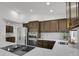 Modern kitchen featuring stainless steel appliances, granite countertops, and dark wood cabinets at 1894 S Marshall Cir, Lakewood, CO 80232