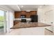 Open kitchen featuring a center island, dark cabinetry, black appliances, and a sliding door to outside at 19060 E 54Th Pl, Denver, CO 80249