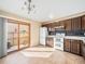Eat-in kitchen with wood cabinets, granite countertops, white appliances, and access to the yard at 8901 Field St # 81, Broomfield, CO 80021