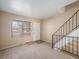 Cozy living area featuring wall-to-wall carpet, large window for natural light, and an adjacent staircase at 8901 Field St # 81, Broomfield, CO 80021