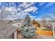 Spacious backyard featuring a large blue spruce tree, wooden fence and green lawn at 9662 Newcastle Dr, Highlands Ranch, CO 80130