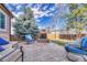 Outdoor patio features a stone fire pit and comfortable seating area with beautiful trees and blue skies at 9662 Newcastle Dr, Highlands Ranch, CO 80130