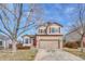 Charming two-story home features a well-maintained lawn and a red front door, with an attached garage at 9662 Newcastle Dr, Highlands Ranch, CO 80130