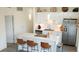 Modern kitchen with stainless steel appliances, white cabinets, island with seating, and pendant lighting at 3500 S Corona St # 206, Englewood, CO 80113