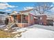 Brick ranch home with a covered porch, steps, and a partially snow-covered front yard at 2895 Dexter St, Denver, CO 80207