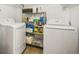 Functional laundry room with washer, dryer, and storage shelves at 2895 Dexter St, Denver, CO 80207