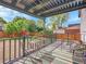 Inviting back deck with outdoor seating, pergola, and a view of the fenced backyard with play area at 1517 S Elkhart St, Aurora, CO 80012