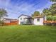 Large, well-maintained backyard with lush green grass, patio, white siding, and partial fence at 1517 S Elkhart St, Aurora, CO 80012