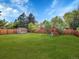 Spacious backyard with a large grassy area, playground, storage shed, and wood privacy fence at 1517 S Elkhart St, Aurora, CO 80012