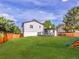 Wide view of the expansive backyard, featuring green grass, a fence, and a partial view of the house at 1517 S Elkhart St, Aurora, CO 80012
