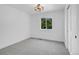 Cozy bedroom featuring gray carpet, a bright window, and a modern geometric light fixture at 1517 S Elkhart St, Aurora, CO 80012