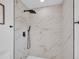 Close-up of a luxurious shower with marble-look tiles and modern matte black rainfall showerhead and fixtures at 1517 S Elkhart St, Aurora, CO 80012