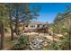Inviting backyard with a deck, patio, outdoor seating, fire pit, professional landscaping, and mature trees at 20413 Bald Mountain Ct, Monument, CO 80132