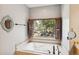 Bathroom with a soaking tub and shuttered window showcasing the backyard at 20413 Bald Mountain Ct, Monument, CO 80132
