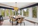 Elegant dining room featuring modern chandelier and views of the lush greenery through large windows at 20413 Bald Mountain Ct, Monument, CO 80132