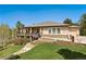 Charming ranch home with a stone facade, landscaped yard, and inviting deck, perfect for outdoor entertaining at 20413 Bald Mountain Ct, Monument, CO 80132