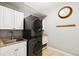 Efficient laundry room with stacked washer/dryer, sink, cabinets and countertop space at 20413 Bald Mountain Ct, Monument, CO 80132