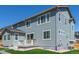 Rear of house view with neutral siding and trim, a patio, green lawn, and stone landscaping details at 434 W 128Th Dr, Westminster, CO 80234