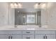 Dual sink bathroom vanity with sleek fixtures and a large mirror reflecting the shower at 434 W 128Th Dr, Westminster, CO 80234