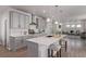 Open kitchen with gray cabinets, stainless steel appliances, island with seating, and view into living area at 434 W 128Th Dr, Westminster, CO 80234