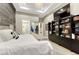 Well-lit bedroom showcases a wood accent wall, ample shelving, and access to the en-suite bathroom at 7600 Landmark Way # 1514, Greenwood Village, CO 80111