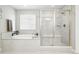 Bright bathroom featuring a soaking tub and glass-enclosed shower, creating a serene and modern spa experience at 1101 E Witherspoon Dr, Elizabeth, CO 80107