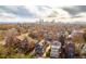 Picturesque aerial view of a neighborhood with houses, trees, and a distant city skyline under a cloudy sky at 1652 N Lafayette St # 1, Denver, CO 80218