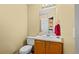 Bathroom with toilet, sink, vanity, and mirror with lights at 10463 Adams St, Northglenn, CO 80233