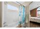 Bright bathroom featuring a shower-tub combination with white tiles and adjacent bedroom access at 10463 Adams St, Northglenn, CO 80233