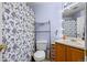 Well-lit bathroom with a white floral shower curtain, vanity, and mirror at 10463 Adams St, Northglenn, CO 80233