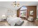 Bright bedroom featuring a ceiling fan, large arched window and light colored wood flooring at 10463 Adams St, Northglenn, CO 80233