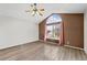 Bedroom featuring a ceiling fan, large arched window and light colored wood flooring at 10463 Adams St, Northglenn, CO 80233